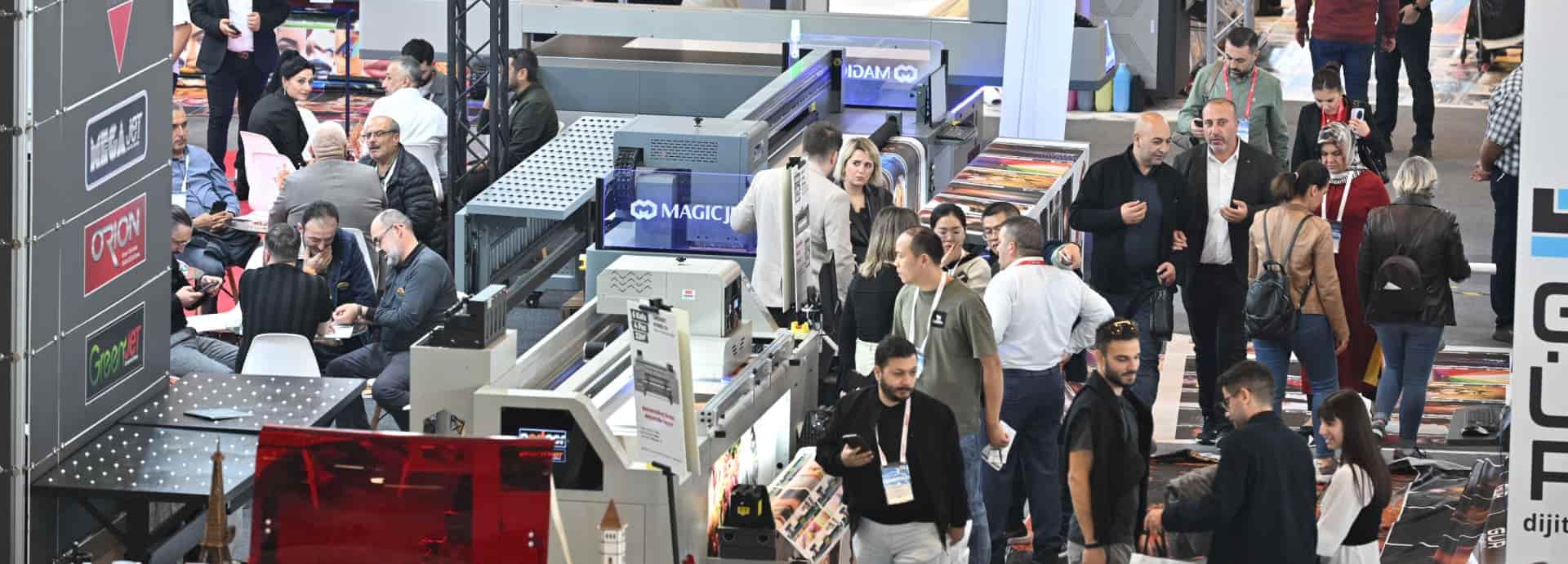 SIGN İstanbul sergisinde dijital baskı teknolojisi ekranlarını inceleyen ziyaretçiler