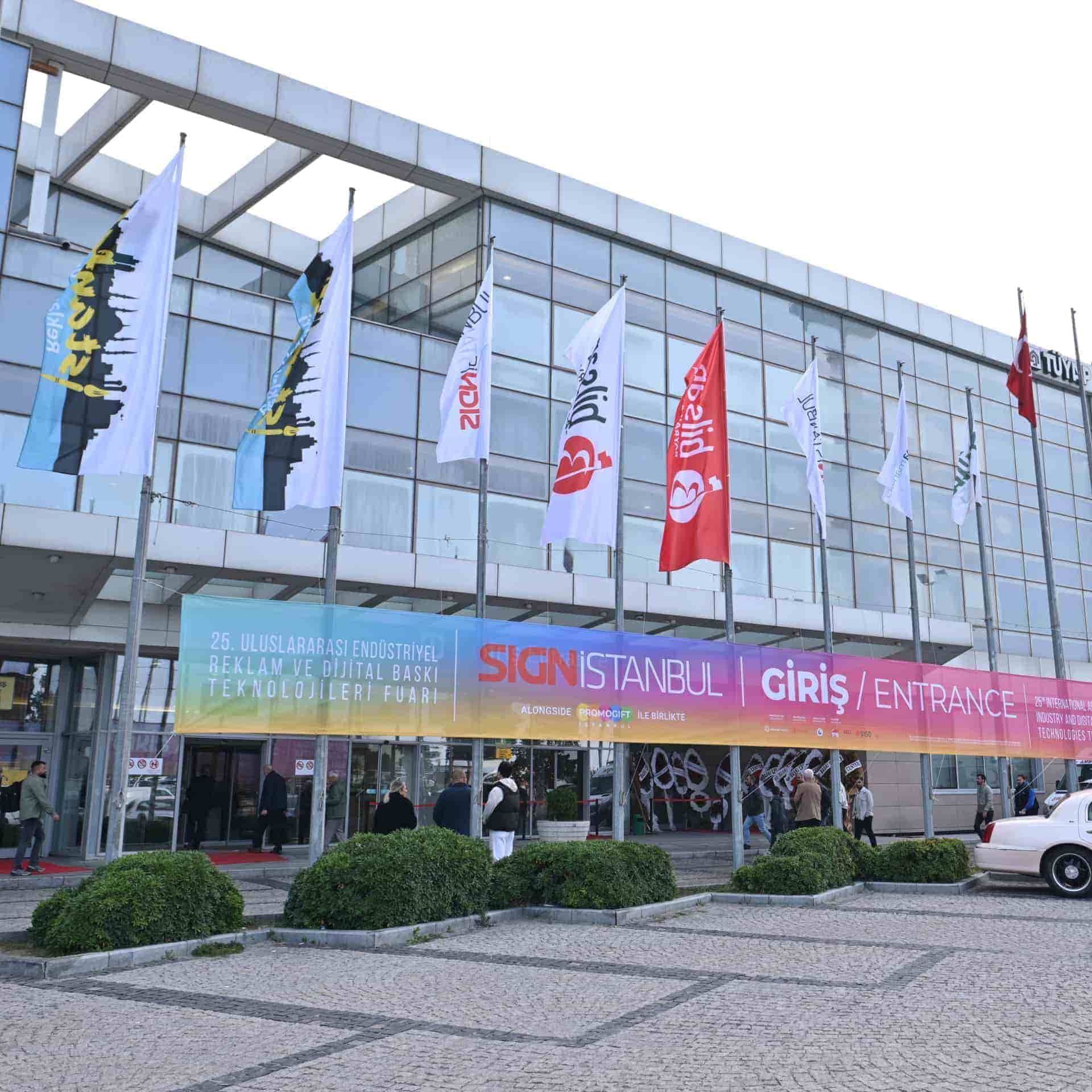 Bayraklar ve canlı bir afişle katılımcıları fuara davet eden SIGN İstanbul girişi