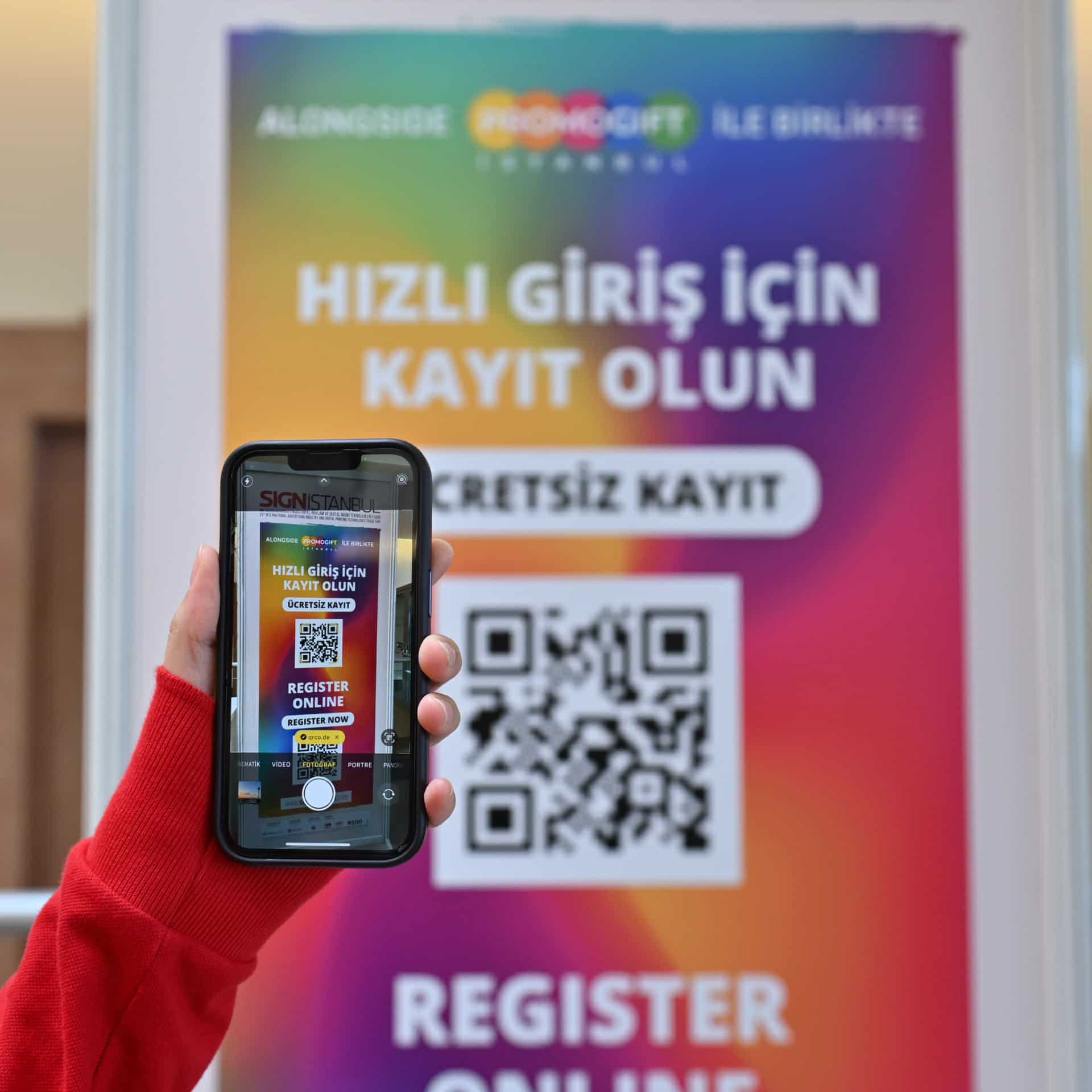  SIGN İstanbul'da hızlı kayıt için QR kodunu tarayan bir el