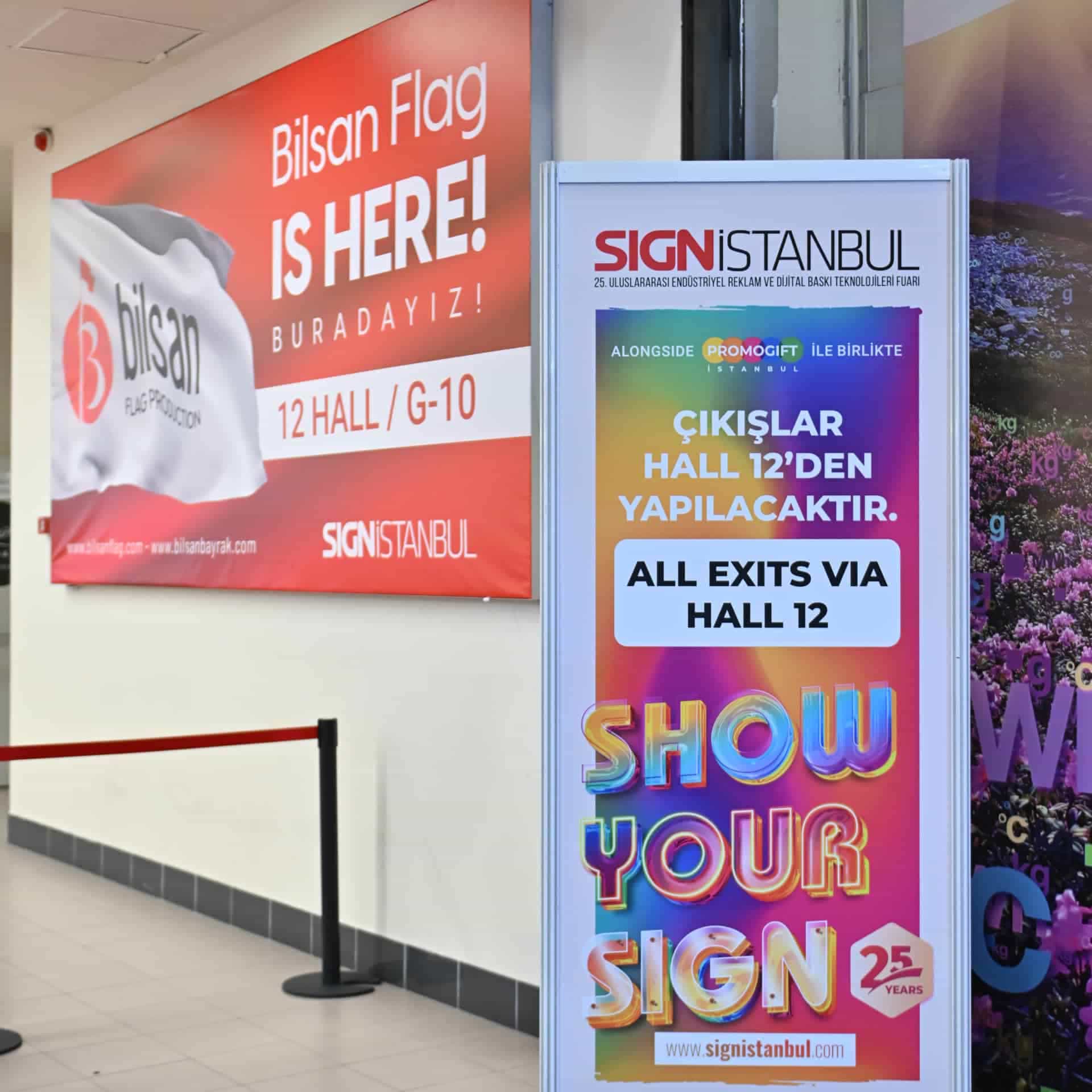 Trade show entrance with colorful event signage directing attendees to designated halls and exhibition areas