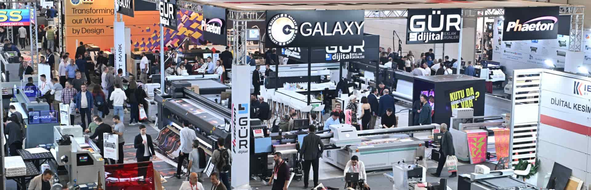 Aerial view of an exhibition floor with multiple booths showcasing printing technology and equipment