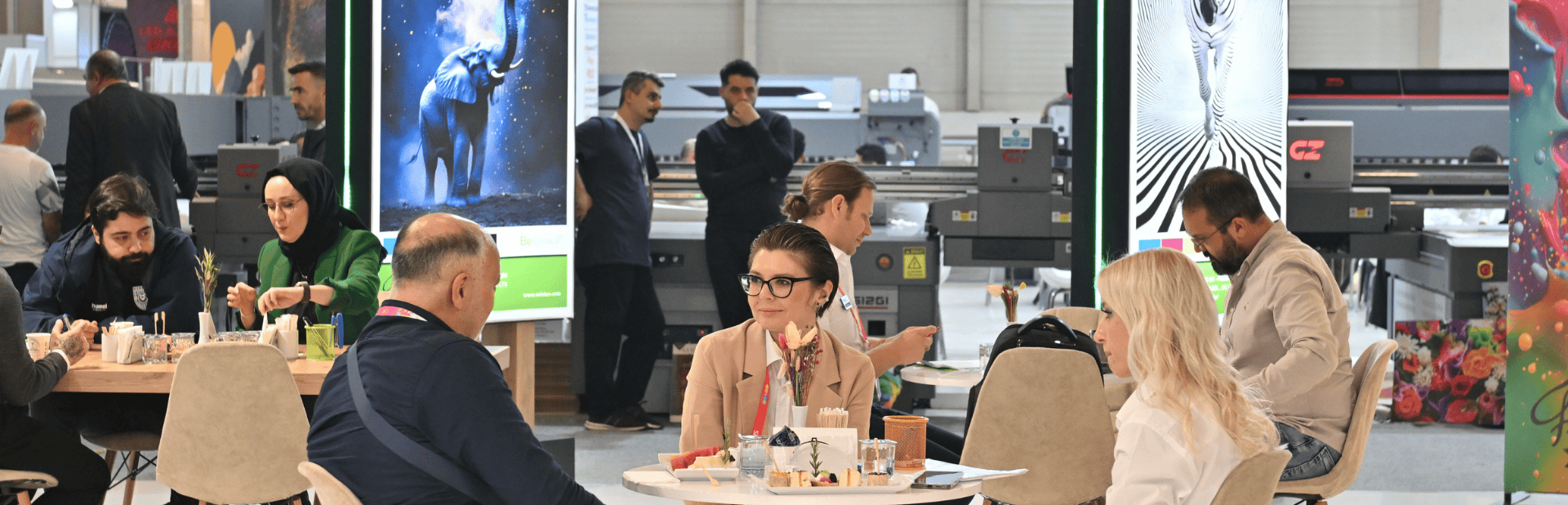 Bir katılımcı ziyaretçilere elektronik mutfak eşyalarını tanıtıyor ve bilgi veriyor.