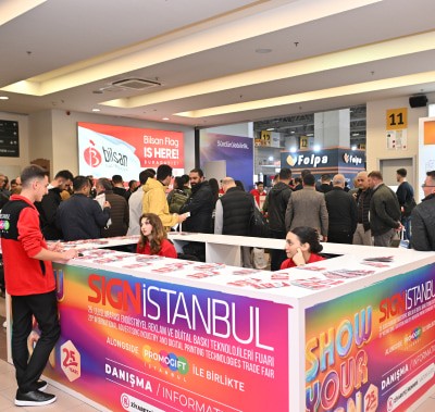 SIGN İstanbul için kayıt masasında etkinlik materyalleri ve rozetler alırken bir araya gelen katılımcılar