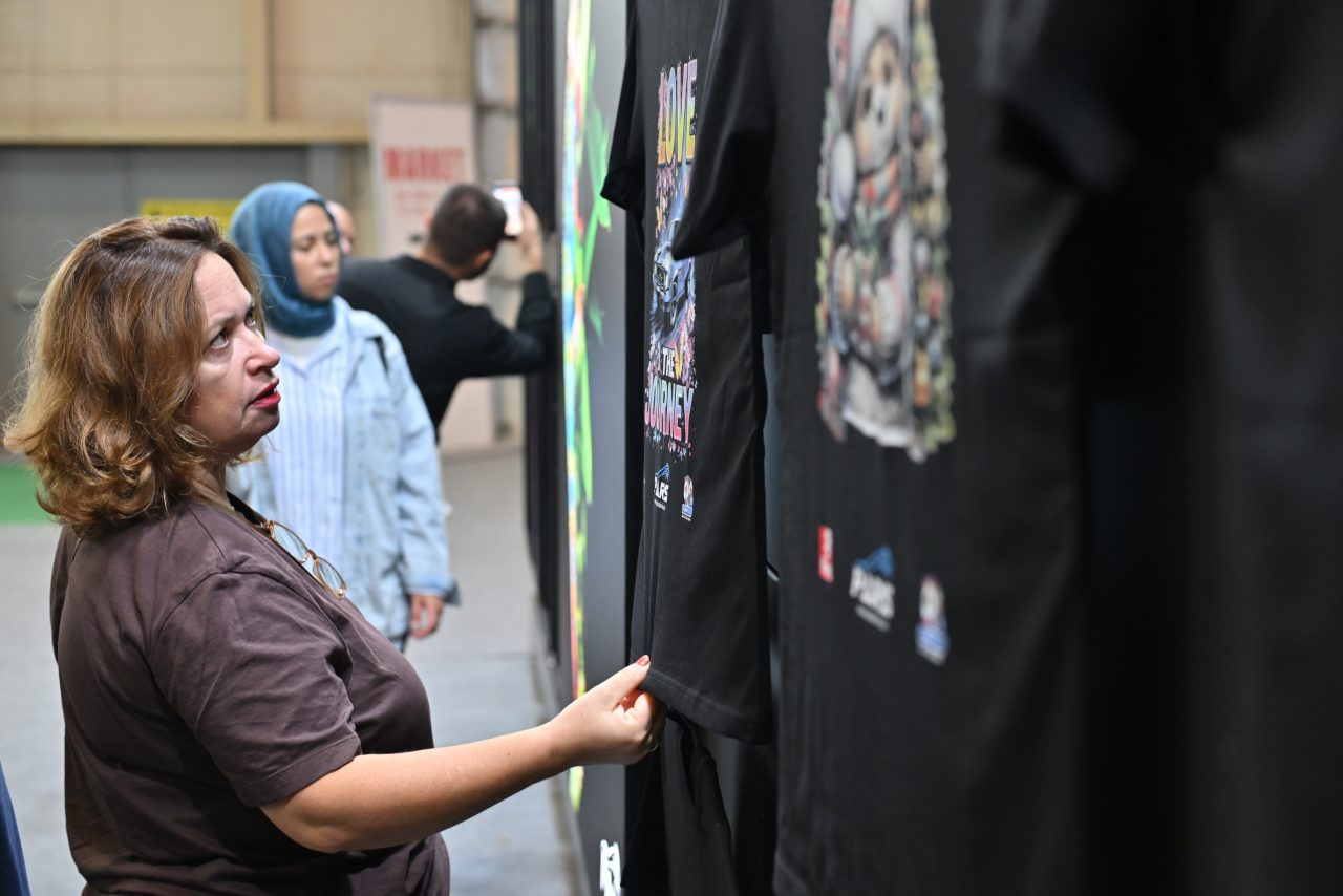 SIGN İstanbul için kayıt masasında etkinlik materyalleri ve rozetler alırken bir araya gelen katılımcılar