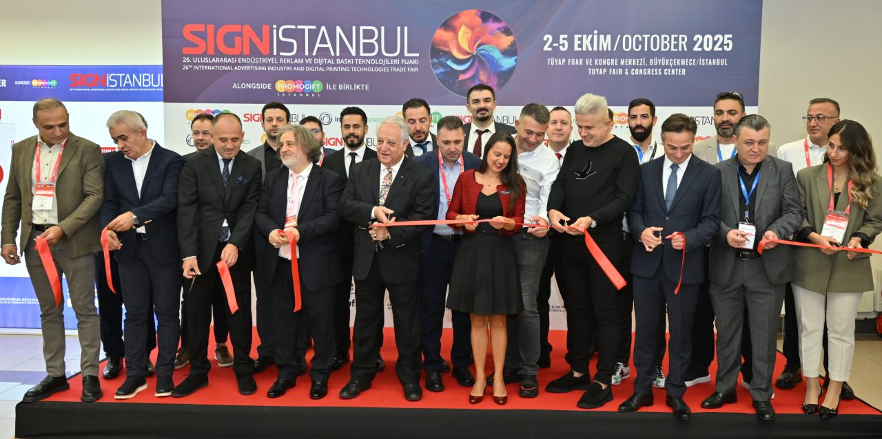 SIGN İstanbul ekibinden üç üye, kırmızı halıda arka planda poz veriyor