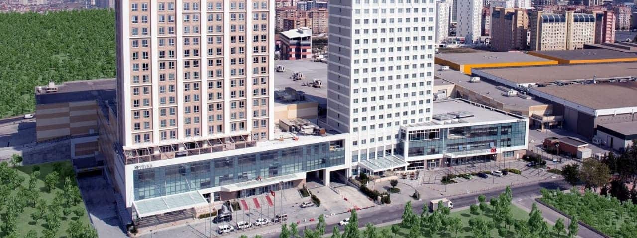 Modern tasarımıyla Tüyap Palas Hotel’in dış görünümü, ağaçlar ve yapılarla çevrili.