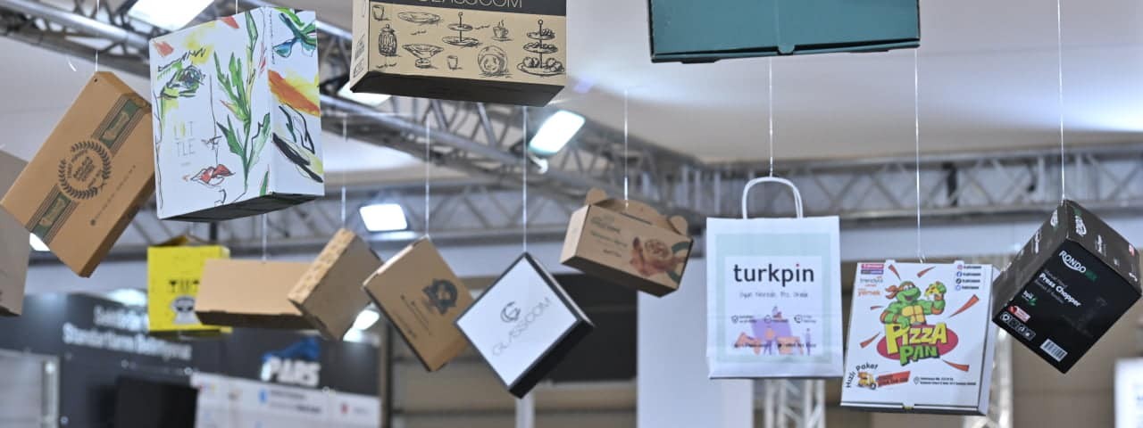 Various hanging printed cardboard boxes with unique artwork on display at Sign Istanbul