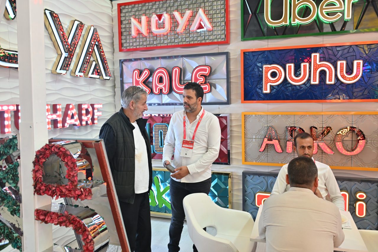 SIGN İstanbul'da büyük ölçekli bir baskı makinesiyle etkileşimde bulunan ziyaretçi